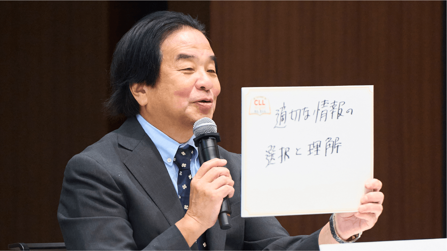 青木定夫先生がフリップを掲げる様子
