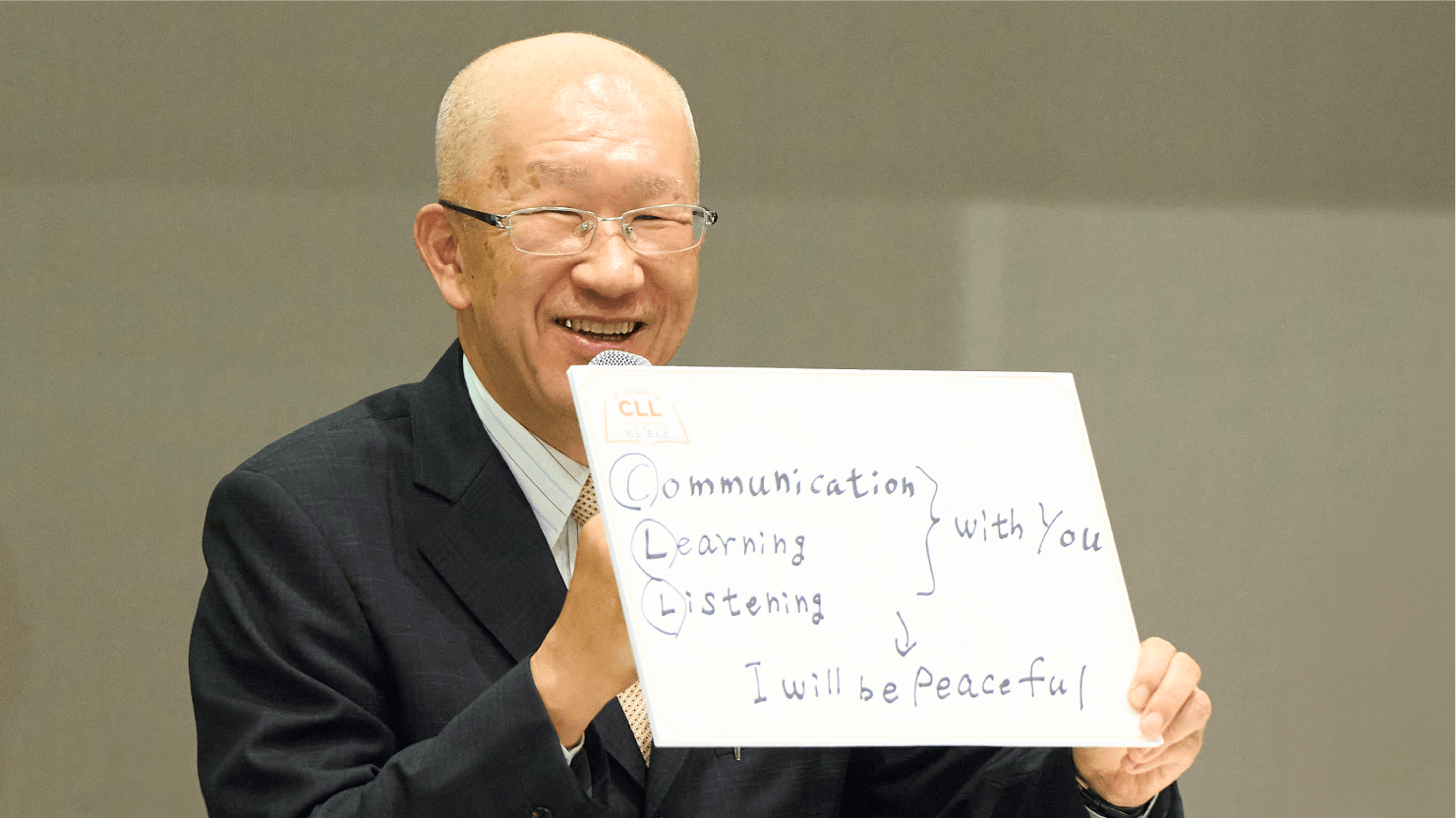 齊藤治夫さんがフリップを掲げる様子