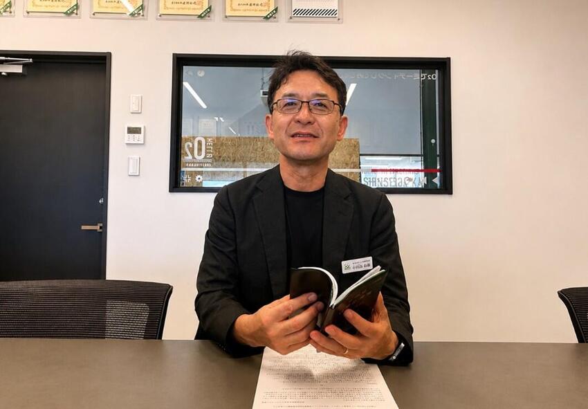 経営計画書を手にする小田島社長。毎年更新し、全社員に配っている