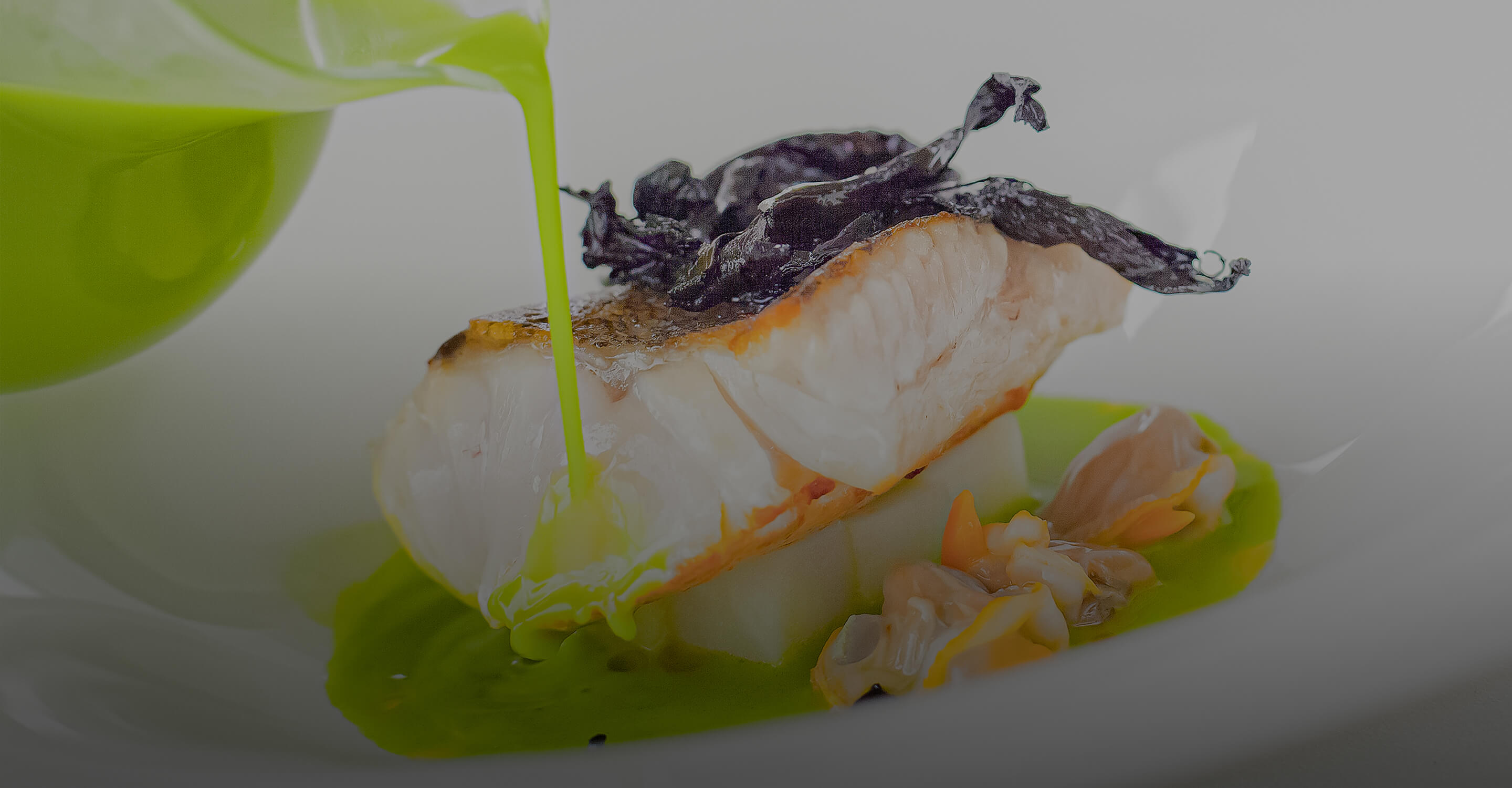 緑のソースが注がれるスペインのモダンな魚料理