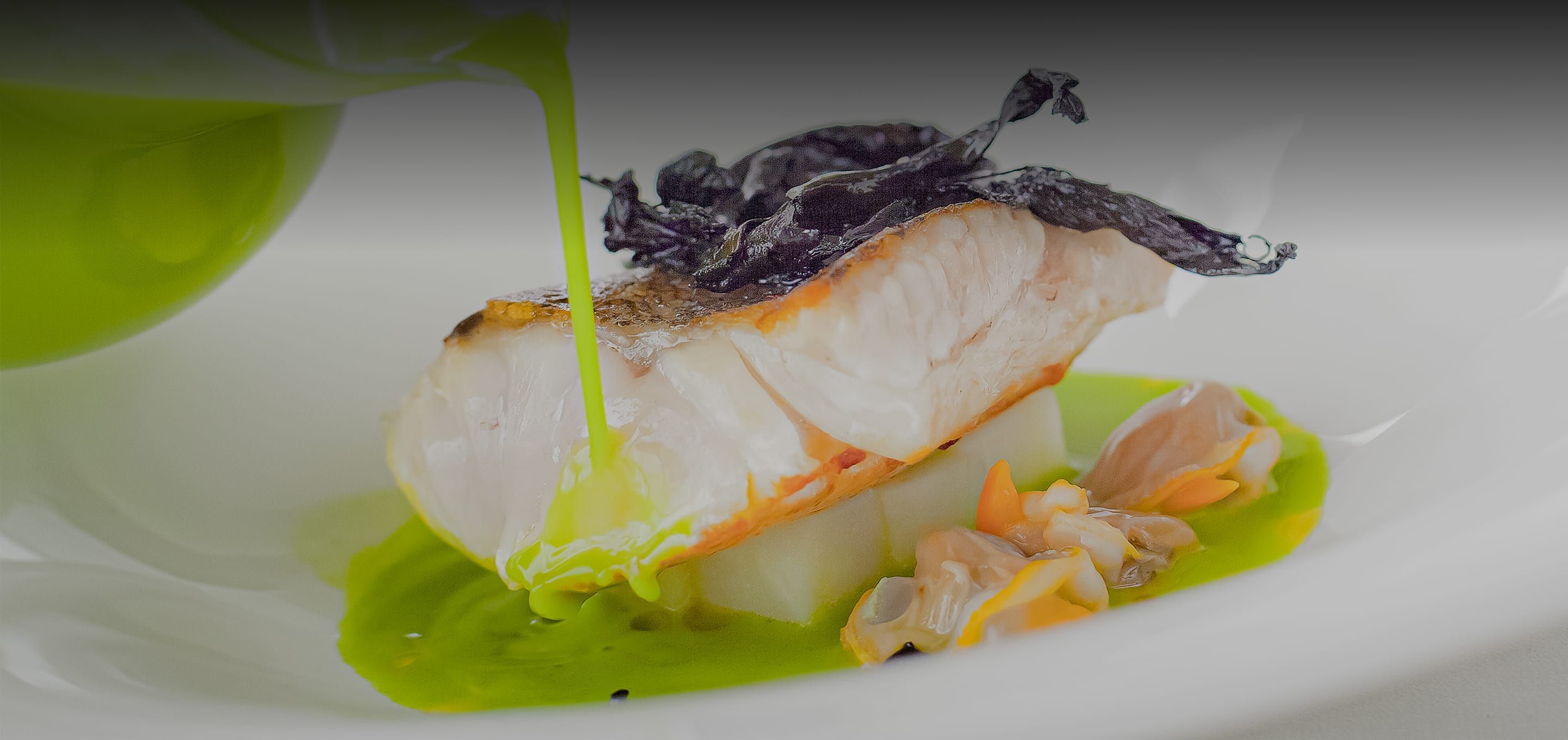 緑のソースが注がれるスペインのモダンな魚料理