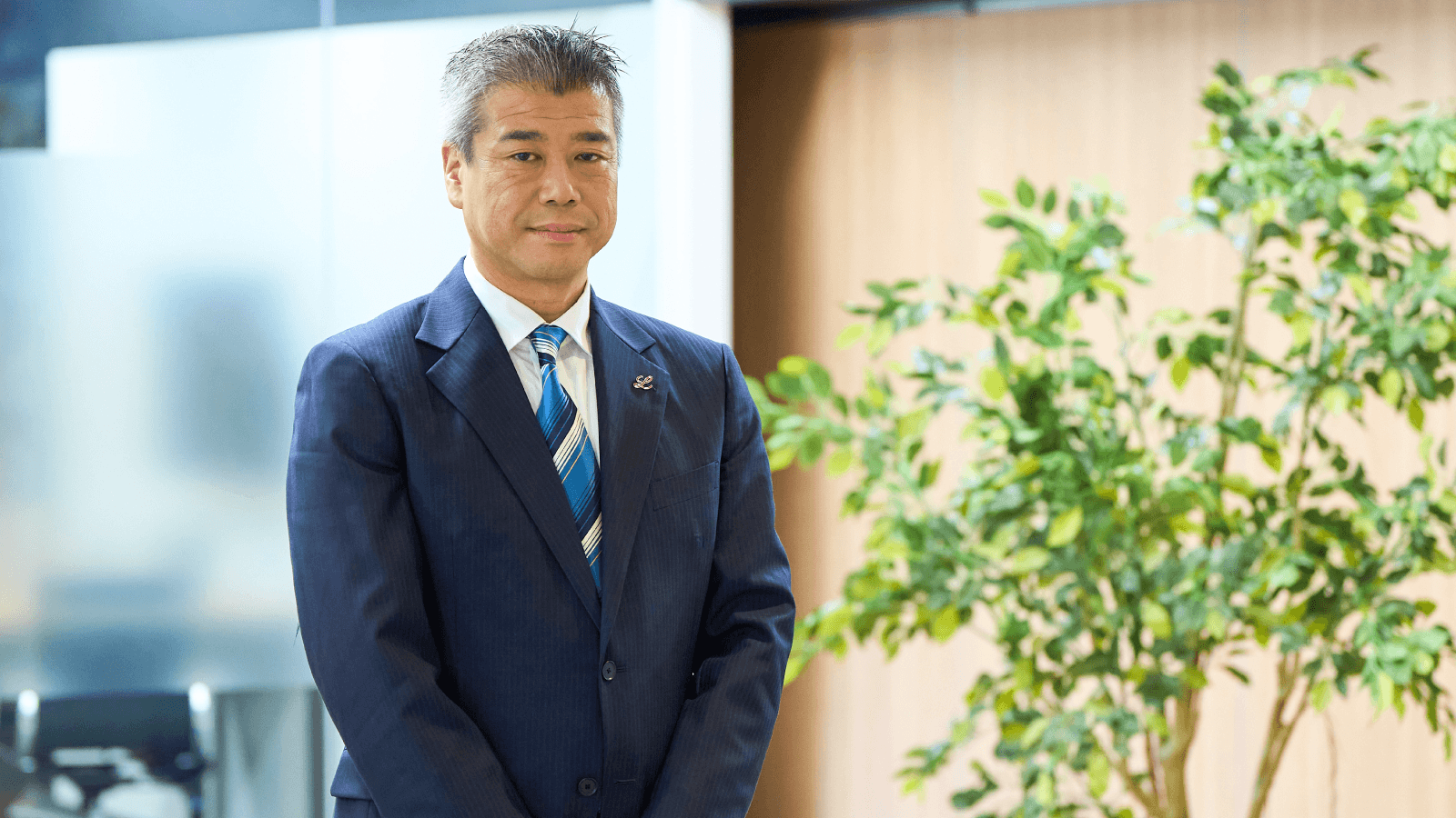 オフィスで微笑む小嶋毅彦